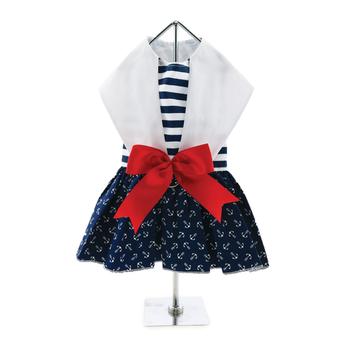 Dog outfit with white top, navy skirt with anchor pattern, and red bow on a mannequin against a white background.